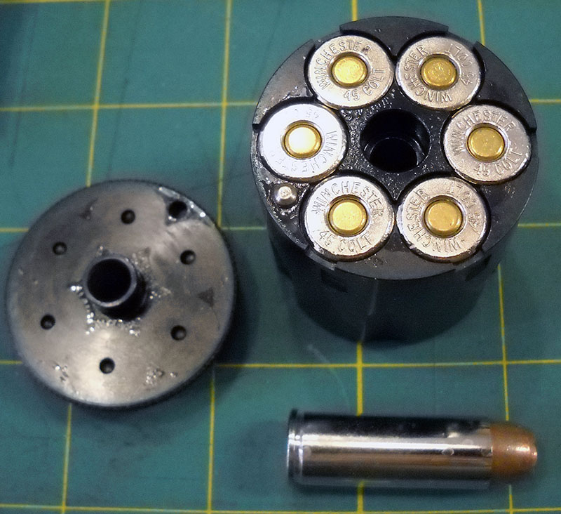 detail, cartridge conversion cylinder with .45 LC cartridges inserted, plus a spare cartridge